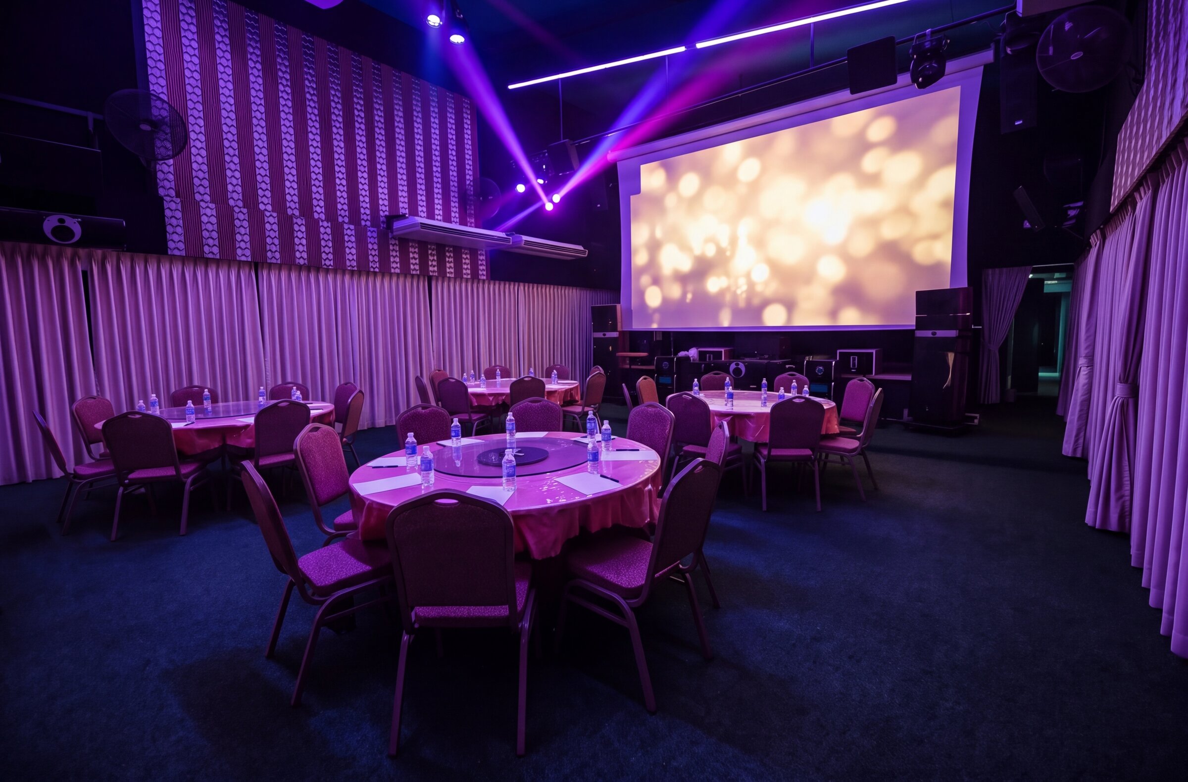 The exact same Emerald Hall view in party mode with purple lighting and the stage lit